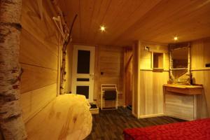 1 dormitorio con 1 cama en una habitación de madera en Le Chal'home, montagne et nature en Campan