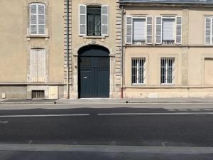 un bâtiment avec une porte noire dans une rue dans l'établissement Élégant T4 Centre Reims/Parking Privé, à Reims