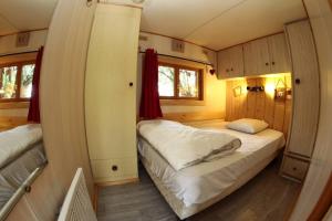 1 dormitorio con 2 camas en una habitación pequeña en Le Chal'home, montagne et nature en Campan
