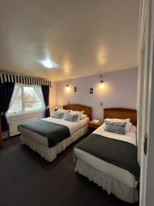 a hotel room with two beds and a window at Montepiedra Costanera Valdivia in Valdivia