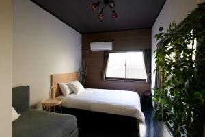 a bedroom with a bed and a window and a plant at Awaji Aqua Marine Resort Building No, 2 - Vacation STAY 09357v in Awaji