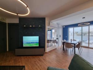 a living room with a tv and a dining table at KORZO SUITES MSIDA LUXURY PENTHOUSE WITH POOL in Msida