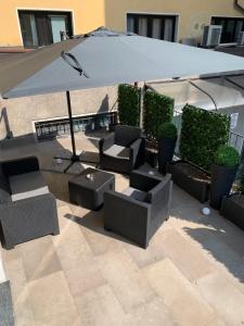 an outdoor patio with chairs and an umbrella at Milan Center Apartment Studio - Porta Romana in Milan