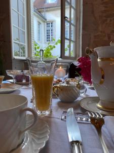 a table with a glass of orange juice on a table at L'APPARTEMENT by Merveilles de Marie in Lons-le-Saunier