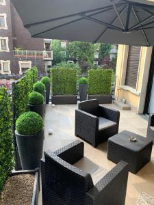 a patio with chairs and tables and an umbrella at Milan Center Apartment Studio - Porta Romana in Milan