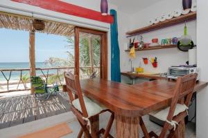 a kitchen with a wooden table and a view of the ocean at El Secreto Xpuha in Xpu Ha