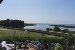 Horse Island View Luxury Retreat في Kircubbin: بلكونه مطله على جسم ماء