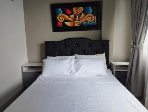 a bed with a black headboard in a bedroom at Apartamento mirador 1 in Melgar