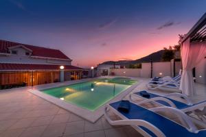 - une piscine dans une arrière-cour entourée de chaises dans l'établissement Villa Anny, à Mokošica