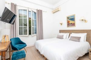 a bedroom with a bed and a desk and a tv at Hôtel Beau Site - Cap d'Antibes in Antibes