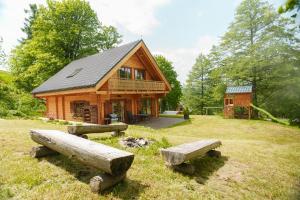 a log cabin with two benches in front of it at Rodinná roubenka U Tří skřítků in Červená Voda