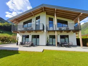a large house with a balcony and lawn at Alpen Aparts Alteck in Rauris