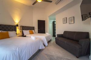 una habitación de hotel con dos camas y un sofá en Casa Nicolasa Alberca y Asador Privados., en Puerto Vallarta 25 fotos más