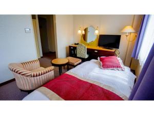 朝来市にあるHotel AreaOne Wadayama - Vacation STAY 10548vのベッド、椅子、鏡が備わる客室です。