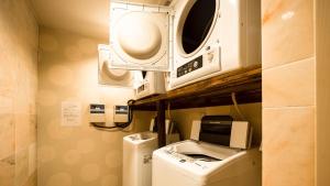 朝来市にあるHotel AreaOne Wadayama - Vacation STAY 10548vのランドリールーム(棚の上に洗濯機と乾燥機付)