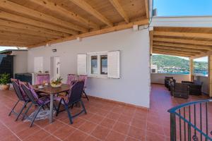 Cette chambre dispose d'une terrasse avec une table et des chaises. dans l'établissement Villa Anny, à Mokošica