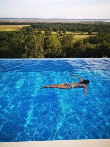 un hombre nadando en una gran piscina azul en Solana's View en Ulcinj