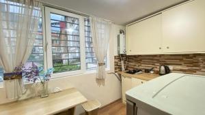 a kitchen with a table and two windows at Freedom Square apartment in Tbilisi City