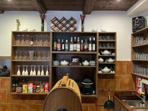una cocina con estanterías de botellas de vino y copas en SG chalupa ŠTIKOV - Podkrkonoší - s celoročním privátním wellness, en Nová Paka
