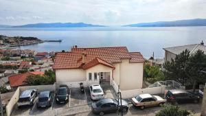 a group of cars parked in a parking lot in front of a house at Apartments Antonio in Senj