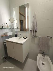 a white bathroom with a sink and a toilet at Casa vacanze Piccolo in Tarvisio