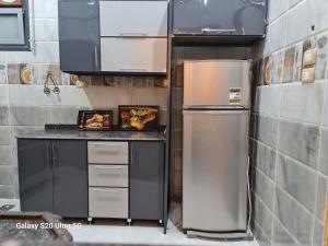 Moon Adam hostel في ‘Ezbet Abu Ḥabashi: مطبخ مع ثلاجة حديد مقاول للصدأ وخزانة