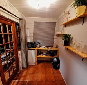 a kitchen with a table and a counter in a room at Woodgate Cottage in Howick