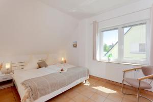 um quarto branco com uma cama e uma janela em MEERerholung em Zinnowitz