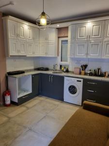 a kitchen with white cabinets and a washing machine at El Mundo Suites in Antalya