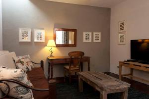 Una sala de estar con un sofá, una mesa y un televisor. en Casa Robelina 4bd+4bths. Center., en San Miguel de Allende