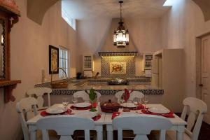 a dining room with a white table and white chairs at Casa Robelina 4bd+4bths. Center. in San Miguel de Allende