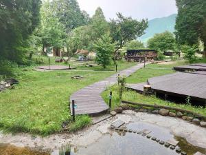 una pasarela de madera con un estanque en un patio en Minamiaso STAYHAPPY - Vacation STAY 57896v en Shimoda