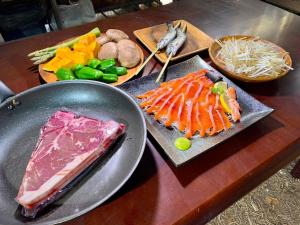 una mesa cubierta con diferentes tipos de carne y hortalizas en Minamiaso STAYHAPPY - Vacation STAY 57924v, en Shimoda