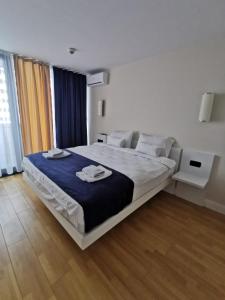 um quarto com uma cama grande e um cobertor azul em OrbiRest in Batumi em Batumi