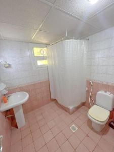 a pink bathroom with a toilet and a sink at Al Ghadeer Hotel Apartment in Sharjah