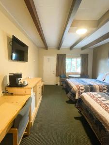 a hotel room with two beds and a flat screen tv at Spirit Lake Lodge in Grand Lake