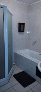 La salle de bains est pourvue d'une baignoire et d'un lavabo. dans l'établissement A Beach Condo, à Durban