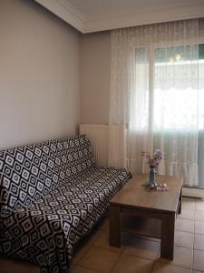 a bedroom with a bed and a table and a window at Dimitris apartment in Paleo Tsifliki