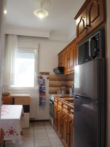 a kitchen with wooden cabinets and a stainless steel refrigerator at Dimitris apartment in Paleo Tsifliki
