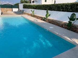a blue swimming pool with two lounge chairs next to it at Apto. S'aigua dolça 1 in Son Carrio