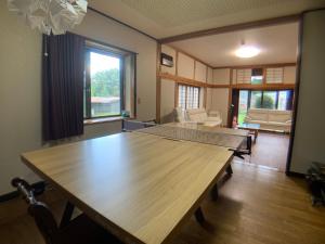 einen großen Holztisch im Wohnzimmer in der Unterkunft Inadani Villa - Vacation STAY 14589 in Ina