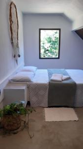 Un dormitorio con una cama grande y una ventana en Chalé à 300 m da praia Rasa, com horta orgânica, en Búzios