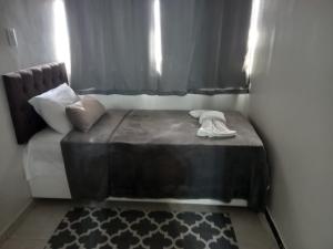 a small bed in a room with a window at Apartamento 1010 in Goiânia