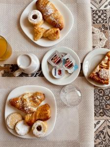 a table with plates of pastries and breads on them at B&B Marco Polo in Terrasini