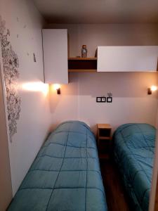 1 dormitorio con 2 camas y un estante encima de ellas en L EVASION, en Pont-Aven