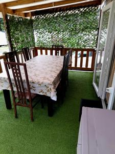 a table and chairs on a porch with green grass at L EVASION in Pont-Aven