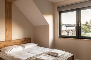 a bedroom with a bed and a window at lotniarzy 15 domy z widokiem na morze in Trzęsacz