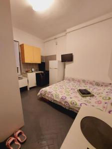a bedroom with a bed and a pair of shoes at Mini studio aproape de centru in Bucharest