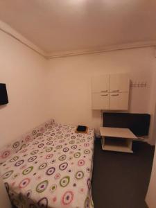 a small bedroom with a bed and a desk at Mini studio aproape de centru in Bucharest