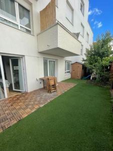 un patio con una mesa en el patio de un edificio en Bel appartement terrasse+jardin en La Courneuve